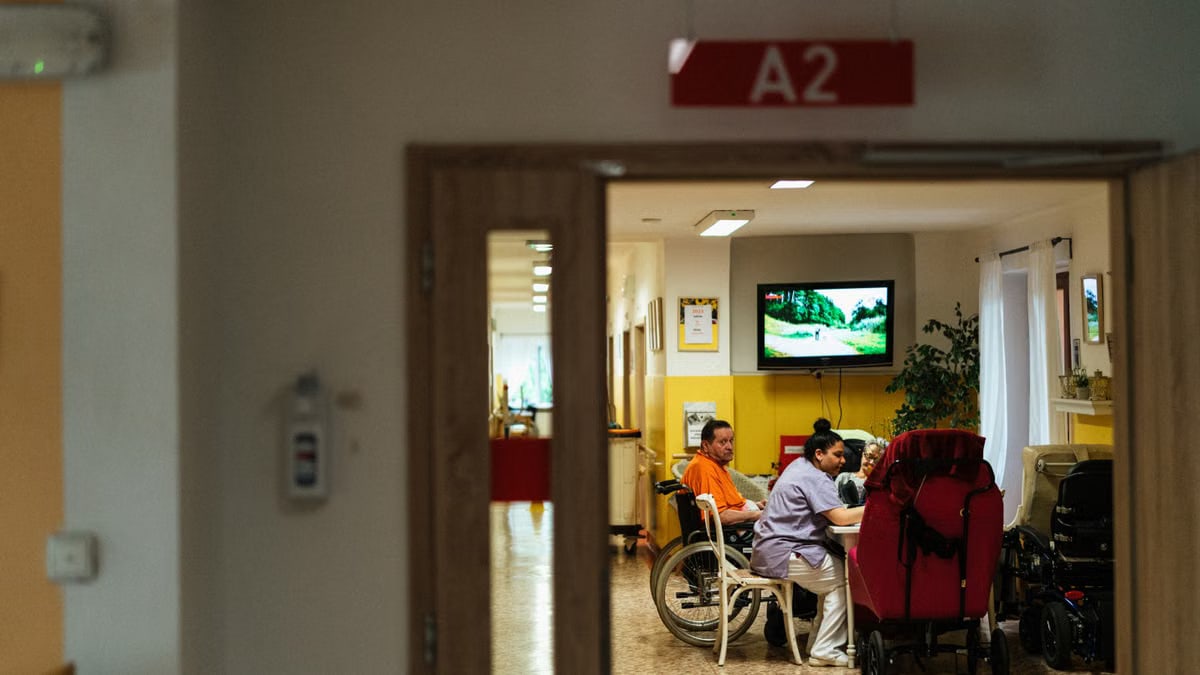 Healthcare professionals caring for elderly patients in a hospital setting, emphasizing support and care.